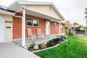 Exterior space featuring a front lawn and covered porch