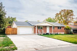 Single story home with a front yard and a garage