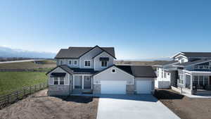 View of front of house featuring a mountain view, a front yard, and a garage