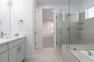 Bathroom featuring a shower with door, vanity, and tile patterned floors