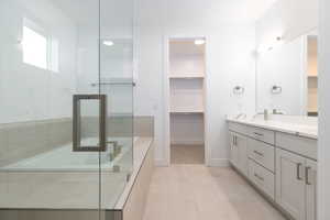 Bathroom featuring vanity, a shower with shower door, and tile patterned floors