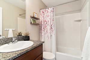 Full bathroom featuring vanity, toilet, and shower / bath combo.