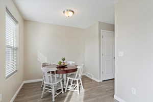 Kitchen featuring granite countertops, LVP flooring, black appliances and large sliding glass door with painted deck.