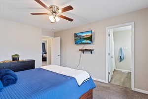 Large owner's bedroom with carpet, large window, separate bathroom, and wall mounted TV.