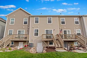 Rear view with wooden deck and access to detached basement/storage.