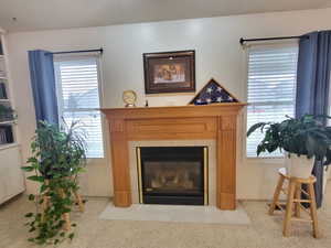 Room details featuring a tiled fireplace and carpet floors