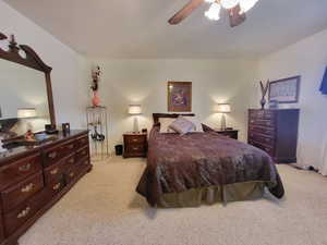 Carpeted bedroom featuring ceiling fan