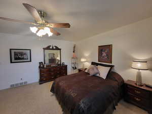 Carpeted bedroom featuring ceiling fan