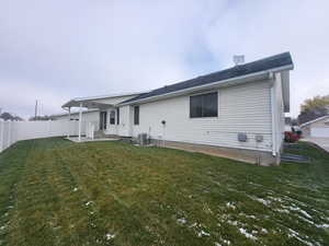 Back of house with a yard, central air condition unit, and a patio