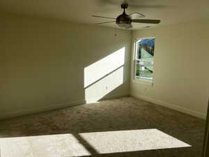 Carpeted empty room with ceiling fan