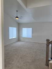 Unfurnished room with ceiling fan, lofted ceiling, and light colored carpet