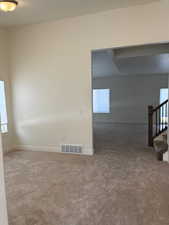 Carpeted spare room featuring a wealth of natural light