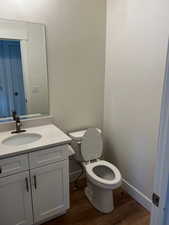 Bathroom featuring vanity, hardwood / wood-style flooring, and toilet