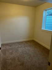 Empty room featuring dark carpet