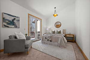 Bedroom featuring light carpet, access to exterior, and vaulted ceiling