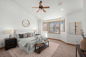 Bedroom featuring vaulted ceiling, ceiling fan, and light colored carpet