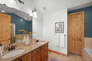 Bathroom featuring lofted ceiling, tile patterned floors, separate shower and tub, and vanity