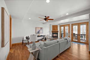 Living room with french doors, ceiling fan, and light hardwood / wood-style floors