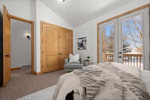 Bedroom with french doors, lofted ceiling, access to exterior, and carpet