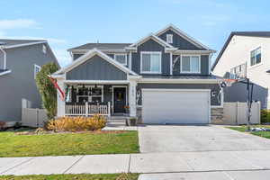 View of front of property with a front yard, a porch, and a garage