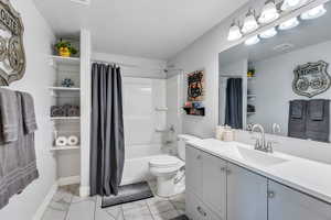 Full bathroom featuring toilet, shower / bath combo, and vanity