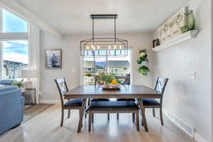 Dining space featuring a notable chandelier and light wood-type flooring