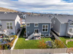 Back of house with a patio, a mountain view, and a yard