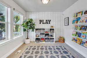 Playroom featuring tile walls and plenty of natural light