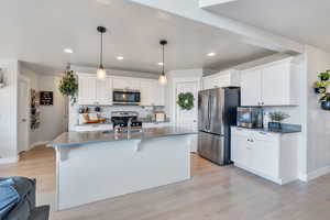 Kitchen featuring sink, white cabinetry, light hardwood / wood-style flooring, and stainless steel appliances