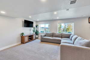 Carpeted living room featuring a textured ceiling