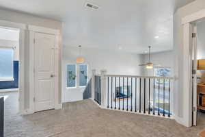 Corridor featuring light colored carpet