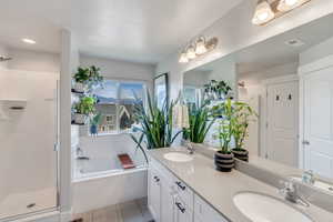 Bathroom with vanity, independent shower and bath, a textured ceiling, and tile patterned flooring