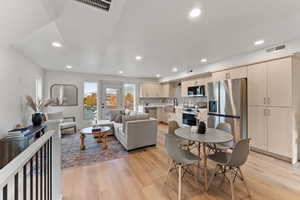 Dining space with sink and light wood-type flooring