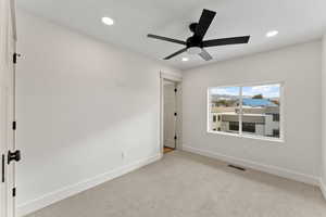 Unfurnished bedroom featuring light carpet and ceiling fan