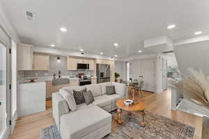 Living room with light hardwood / wood-style flooring and sink