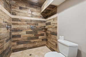 Master Bathroom featuring tiled double head shower and toilet