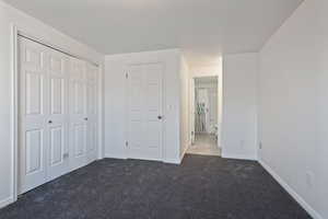 Unfurnished upstairs master suite bedroom featuring a large closet and new carpet