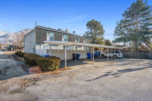 View of vehicle parking with a mountain view and a carport