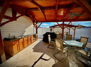 View of patio with wine cooler, a wet bar, a gazebo, area for grilling, and ceiling fan