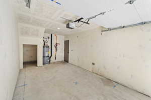 Garage featuring water heater and a garage door opener