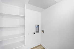 Laundry room with hookup for an electric dryer, hookup for a washing machine, and light hardwood / wood-style floors