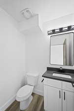 Bathroom featuring vanity, toilet, and wood-type flooring