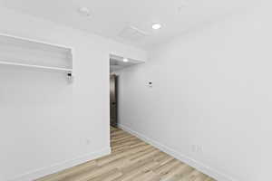 Unfurnished bedroom with light hardwood / wood-style flooring and a closet