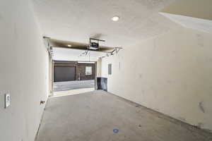 Garage featuring a garage door opener and electric panel