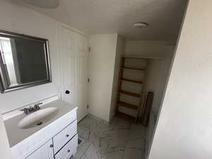 Bathroom with vanity and a textured ceiling