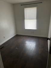 Unfurnished room with dark hardwood / wood-style floors