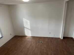 Empty room featuring dark wood-type flooring