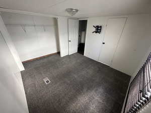 Unfurnished bedroom featuring dark colored carpet