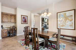 Dining area with an inviting chandelier and a fireplace