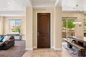 Foyer entrance featuring a notable chandelier and light tile patterned flooring